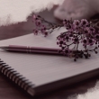Ein Notizblock mit Stift und Blume