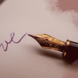 Das Wort "Love" steht auf einem Papier und daneben liegt ein Füller