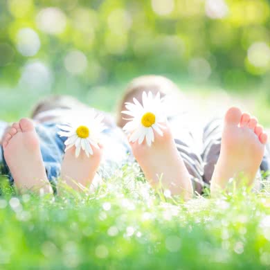 Kinderfüße mit Blumen zwischen den Zehen